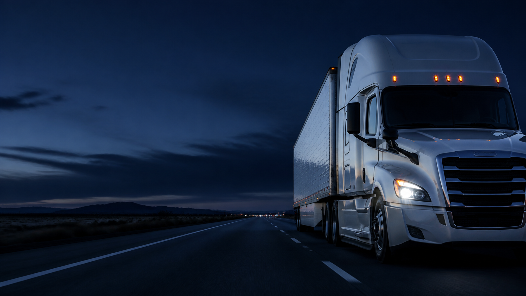 Semi truck driving on an open highway at blue hour